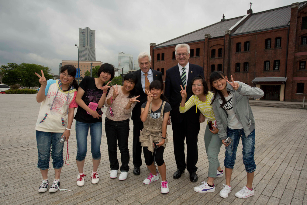 Ministerpräsident Winfried Kretschmann (r.) und der deutsche Botschafter Volker Stanzel (l.) mit japanischen Schülerinnen in Yokohama, Präfektur Kanagawa (Japan)
