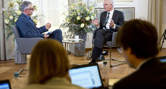 Ministerpräsident Winfried Kretschmann (hinten, r.) beantwortet Fragen bei der Online-Bürgersprechstunde