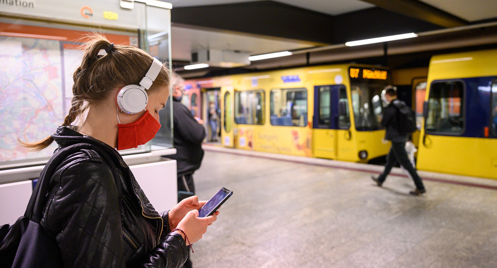 Eine Frau mit Mundschutz steht an einer Haltestelle der Stuttgarter Straßenbahnen (SSB). (Bild: picture alliance/Sebastian Gollnow/dpa)