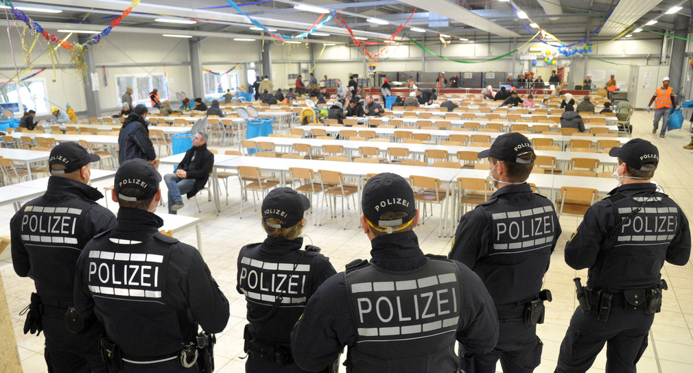 Polizisten stehen in einer Landeserstaufnahmeeinrichtung (Bild: © dpa)