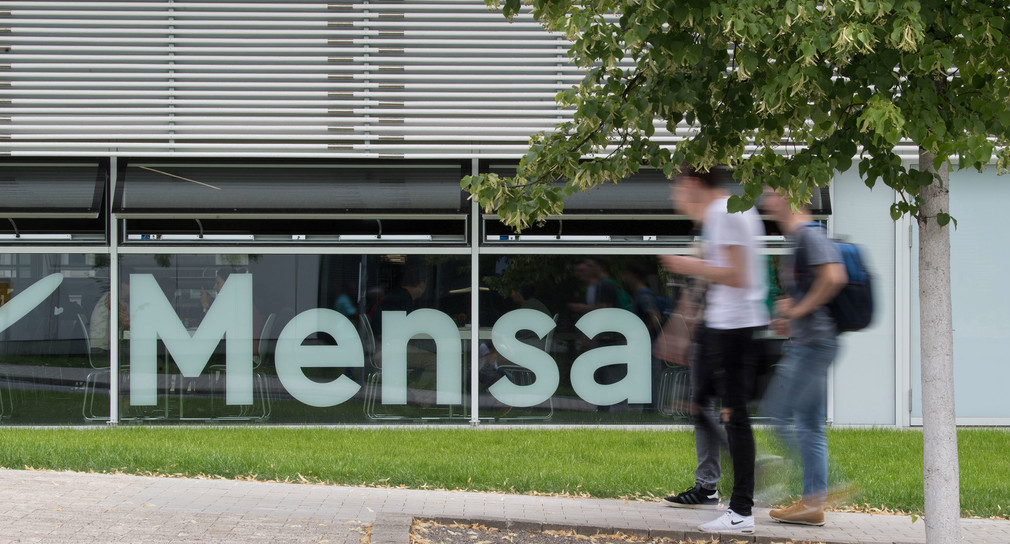 Studierende gehen an der Mensa der Universität Hohenheim vorbei. (Bild: picture alliance/Marijan Murat/dpa)