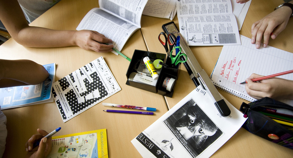 Während der Redaktionssitzung einer Schülerzeitung liegen auf dem Redaktionstisch Blöcke, Stifte, Scheren und Kleber und andere Utensilien. (Foto: © dpa)