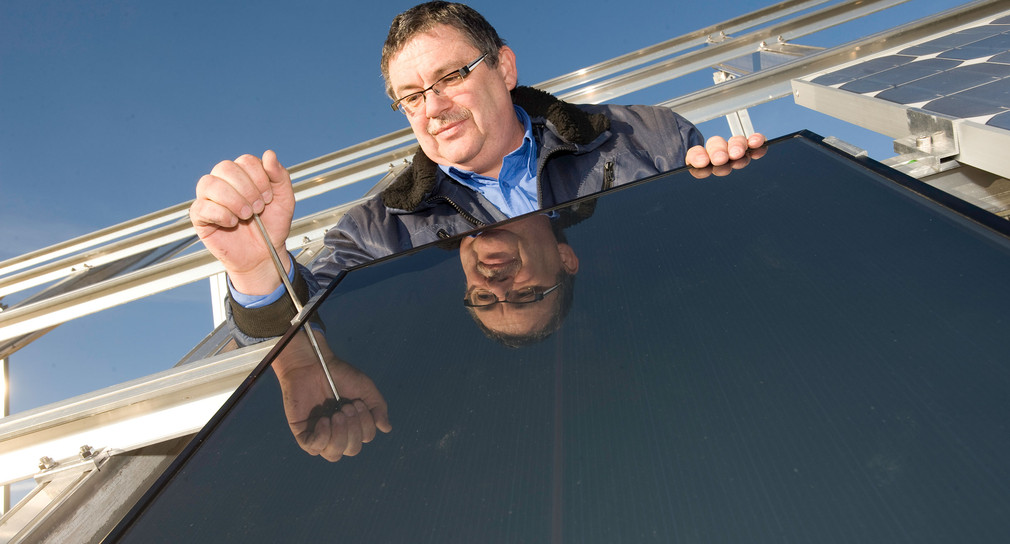 Mann schraubt an Solarzelle