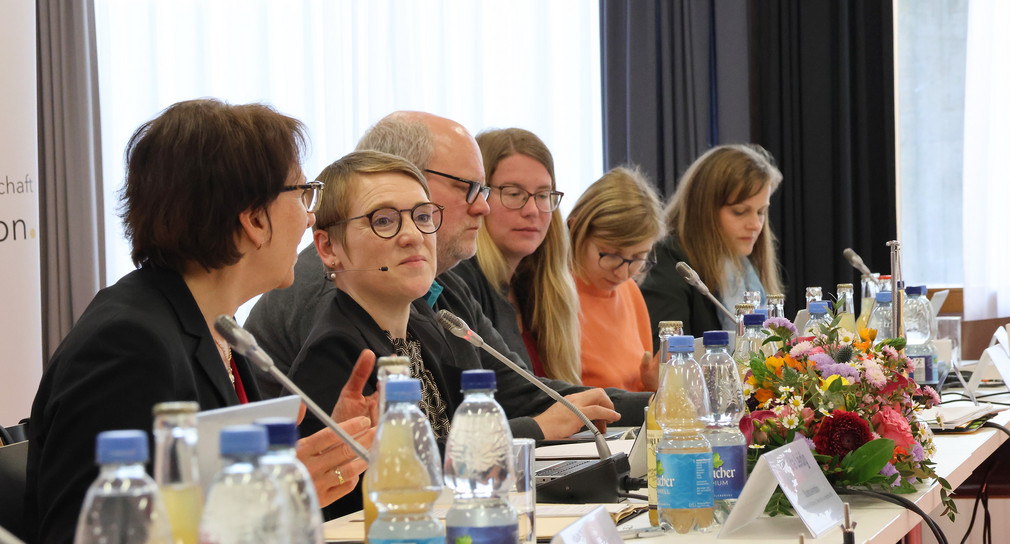Landes-Behindertenbeauftragte Simone Fischer mit Teilnehmenden an Konferenztisch.