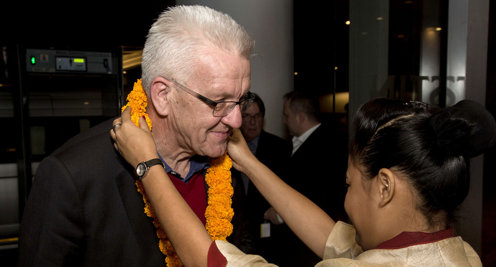 Eine Frau hängt Ministerpräsident Winfried Kretschmann in einem Hotel in Pune (Indien) eine Kette um (Foto: © dpa)