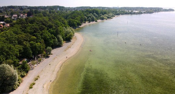 Luftaufnahme des Bodensees mit niedrigem Wasserstand und freigelegtem Uferbereich neben bewaldetem Land