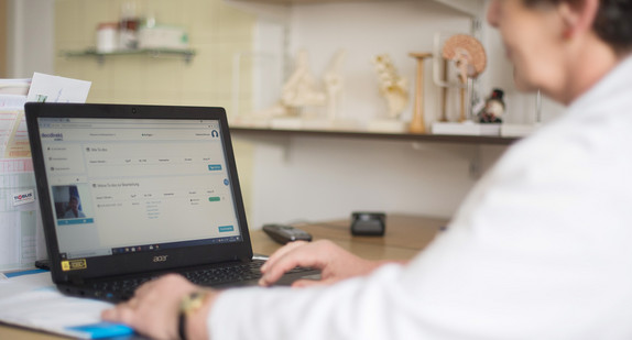 Ärztin arbeitet mit einem Laptop.