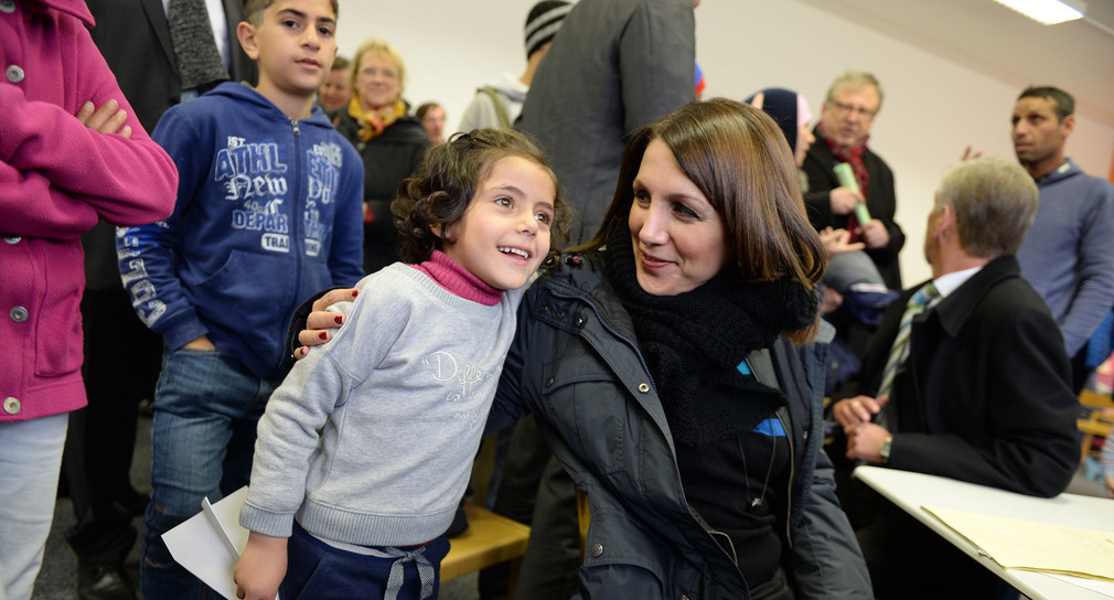 Integrationsministerin Bilkay Öney (r.) umarmt das Asylbewerberkind Lana (l.) (Foto: dpa)