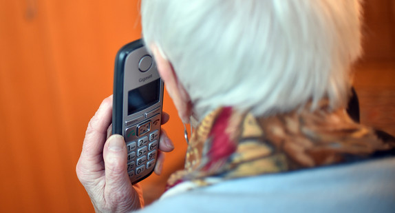 Eine Seniorin hält einen Telefonhörer an ihr Ohr (gestellte Szene). (Bild: picture alliance/Britta Pedersen/zb/dpa)