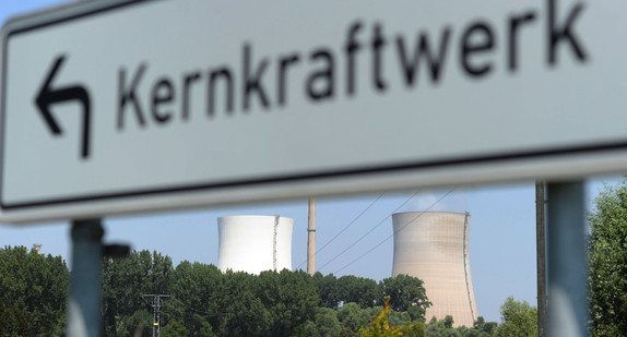 Hinter einem Hinweisschild „Kernkraftwerk“ erheben sich die Kühltürme des Kernkraftwerks Philippsburg. (Foto: © dpa)