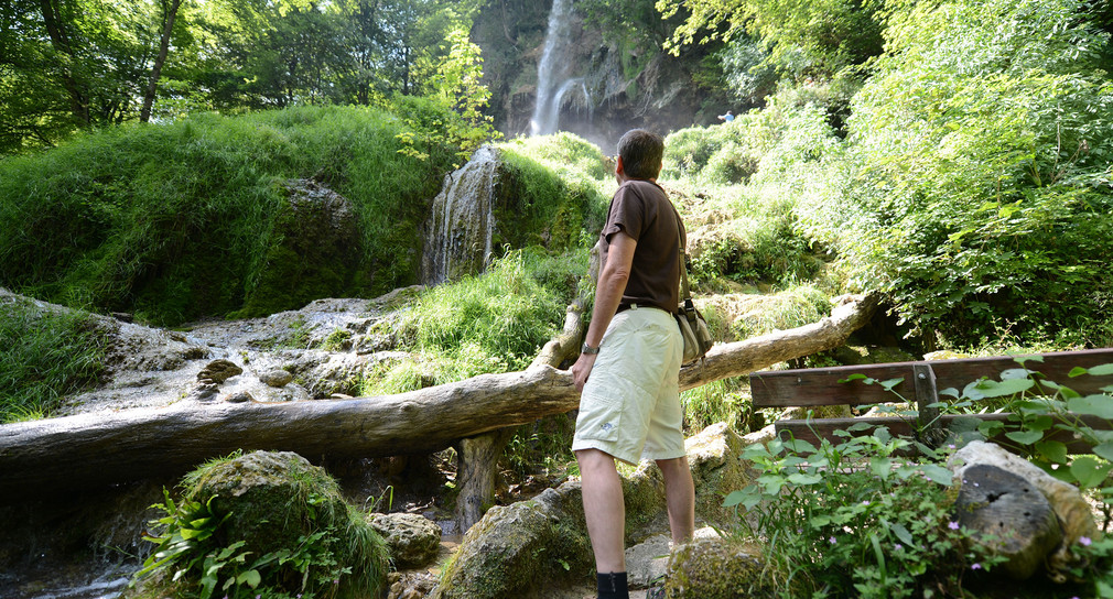 Ein Wanderer betrachtet bei Bad Urach den Uracher Wasserfall. (Bild: dpa)