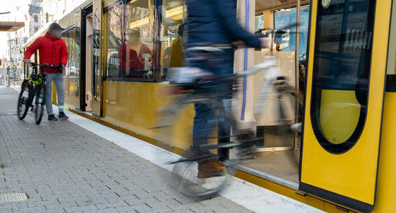 Ein Mensch steigt mit seinem Rad in eine U-Bahn ein.