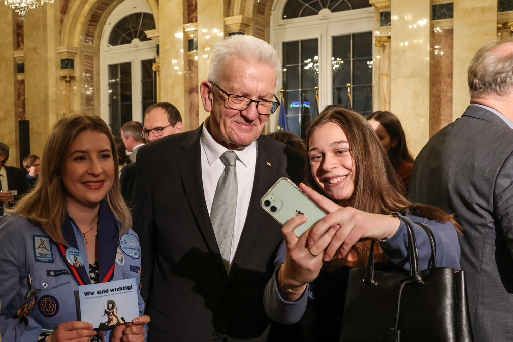 Eine junge Frau macht ein Selfie mit Ministerpräsident Winfried Kretschmann.