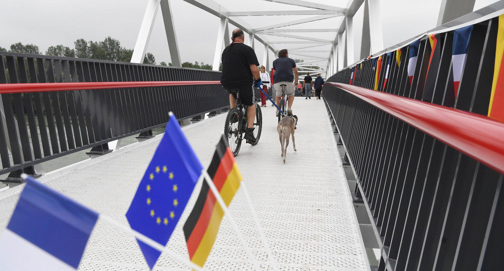 Am deutsch-französischen Rheinübergang Freistett - Gambsheim fahren Fahrradfahrer über die Brücke auf einem Radweg. (Bild: picture alliance/Uli Deck/dpa)