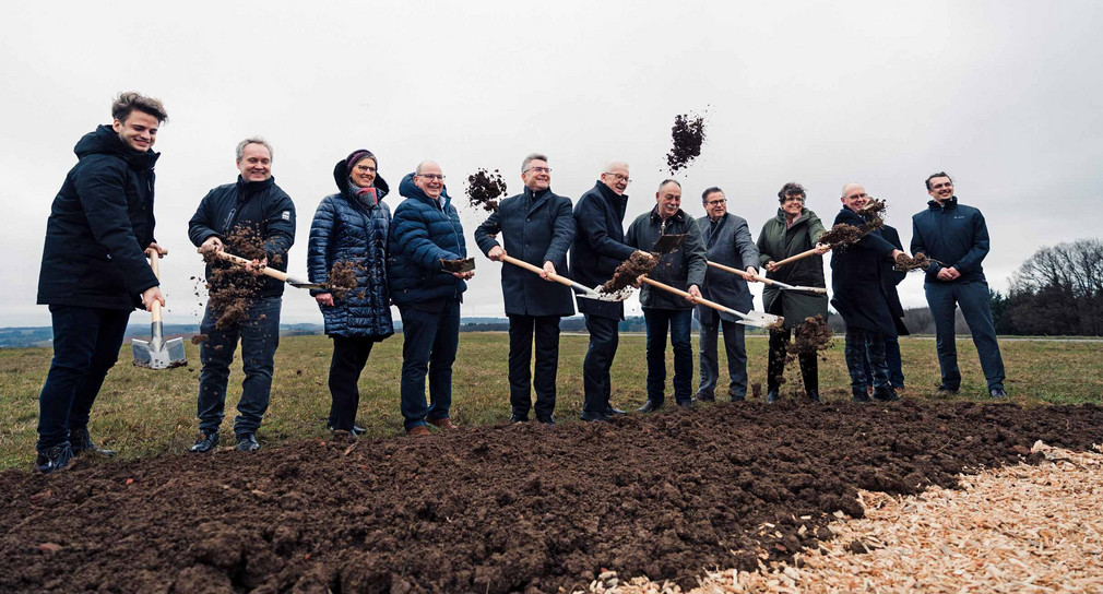 Ministerpräsident Winfried Kretschmann (Mitte) und zehn weitere Personen beim symbolischen Spatenstich für die Erneuerung des Windparks Altheimer Höhe