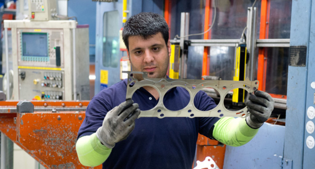 Ein Produktionsmitarbeiter kontrolliert eine Zylinderkopfdichtung. (Foto: dpa)