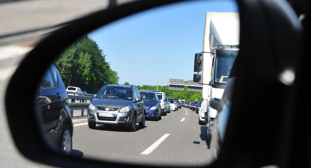 Zahlreiche im Stau stehende Fahrzeuge sind durch den Außenspiegel eines Autos auf der A81 bei Sindelfingen zu sehen. 