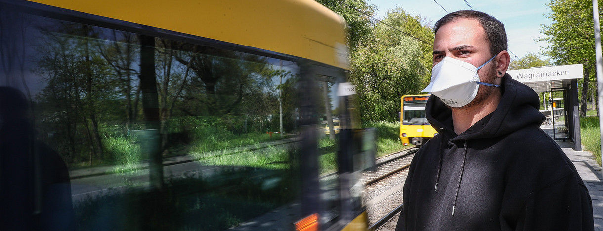 Symbolbild: Ein junger Mann trägt vor einer einfahrenden Stadtbahn in Stuttgart eine Atemschutzmaske. (Bild: picture alliance/Christoph Schmidt/dpa)