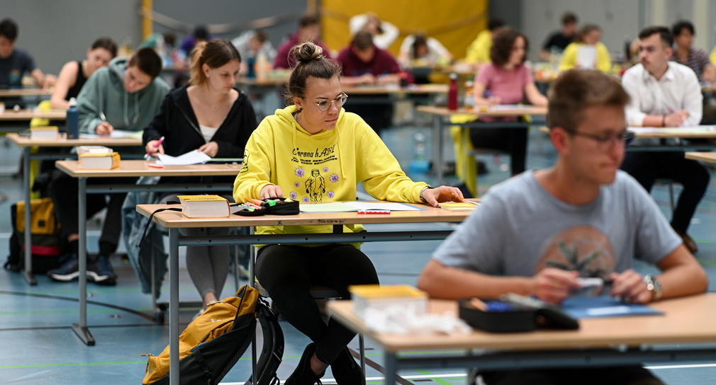 Schüler sitzen während der Deutsch-Abitursprüfung in einer Sporthalle. (Bild: © picture alliance/Felix Kästle/dpa)