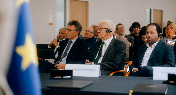 von links nach rechts: Franck Leroy, Präsident der Region Grand Est, Ministerpräsident Winfried Kretschmann und Europa-Staatssekretär Florian Haßler im Centre Européen des Sciences Quantiques (CESQ) in Straßburg