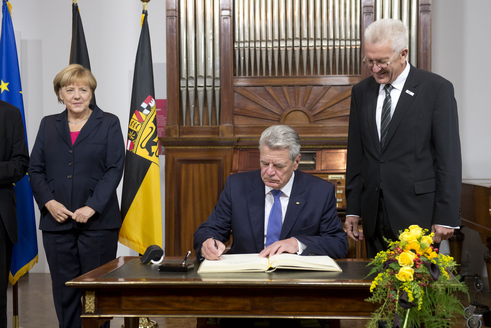 v.l.n.r.: Bundeskanzlerin Angela Merkel, Bundespräsident Joachim Gauck beim Eintrag in das Gästebuch der Landesregierung, Bundesratspräsident Winfried Kretschmann