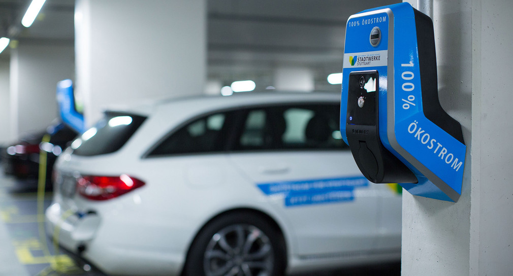 Ein E-Auto tankt in einem Parkhaus an einer Ladesäule Strom