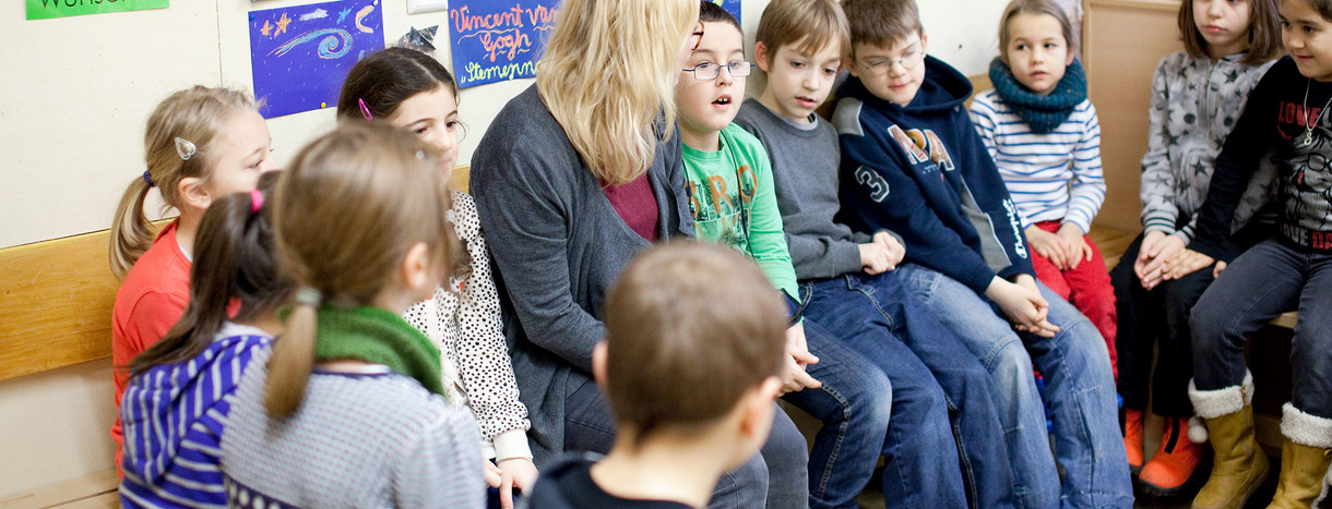Grundschule Schüler hören Lehrerin aufmerksam zu