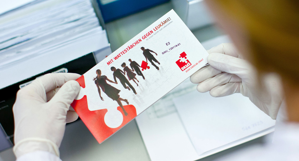 Eine Angestellte hält in der DKMS Life Science Lab GmbH in Dresden einen Briefumschlag für DNS-Proben in ihren Händen (Bild: © dpa)
