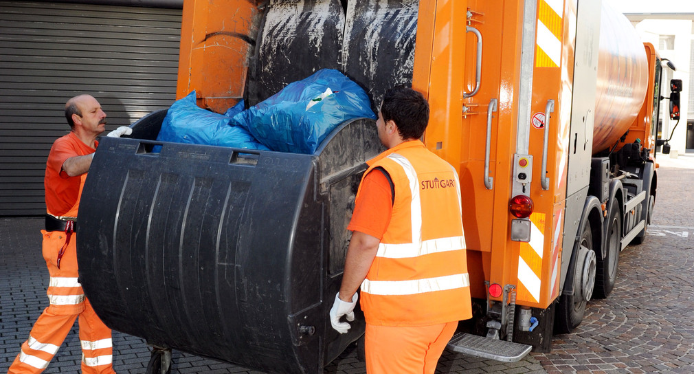 Mitarbeiter der Abfallwirtschaft Stuttgart beladen in der baden-württembergischen Landeshauptstadt Stuttgart einen Müllwagen. (Foto: © dpa)