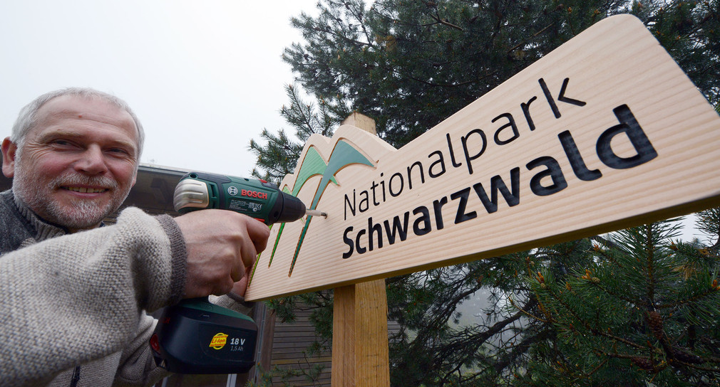 Nationalpark-Direktor Wolfgang Schlund montiert am 29.04.2014 bei Seebach (Baden-Württemberg) am Ruhestein ein Holzschild mit der Aufschrift "Nationalpark Schwarzwald". (Foto: dpa)
