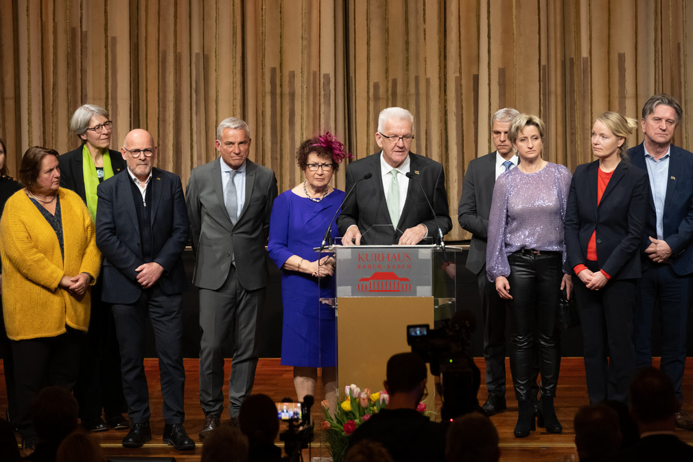 Ministerpräsident Winfried Kretschmann (Mitte) bei seiner Ansprache, neben ihm seine Ehefrau Gerlinde und Mitglieder der Landesregierung.