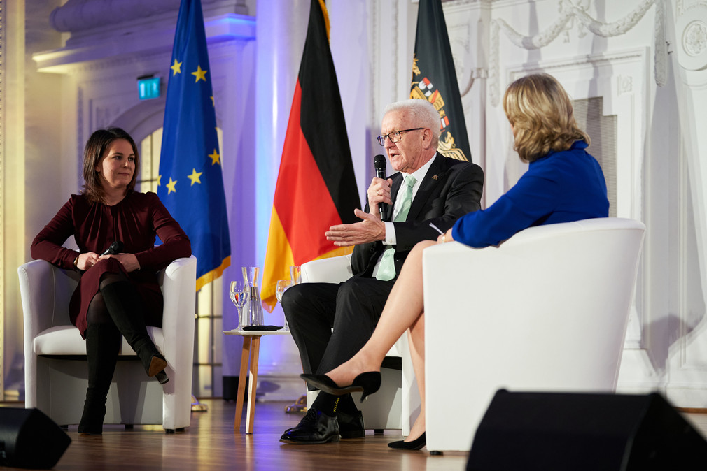 Podiumsdiskussion mit Bundesaußenministerin Annalena Baerbock (links), Ministerpräsident Winfried Kretschmann (Mitte) und Moderatorin Ute Brucker (rechts)