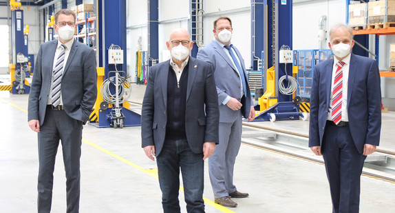 Verschiedene Männer stehen in einer Werkstatthalle zu einem Gruppenbild zusammen, diese Männer sind Tobias Harms (SWEG-Vorstandsvorsitzender), Winfried Hermann (Verkehrsminister Baden-Württemberg), Dr. Thilo Grabo (SWEG-Vorstand) und Johannes Emmelheinz (CEO Customer Service von Siemens Mobility)