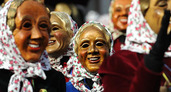 Narren in den lachenden Masken der Staufener "Schnurrewiber" verfolgen am Donnerstag (16.02.2012) in dem Breisgaustädtchen Staufen den Sturm auf das Rathaus. (Foto: dpa)