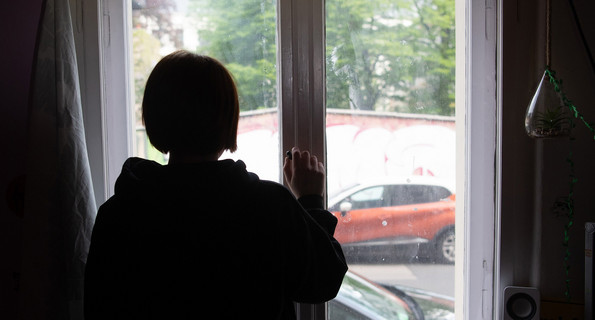 Eine Jugendliche schaut aus dem Fenster.