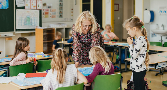 Eine Lehrerin mit Schülerinnen und Schülern in einem Klassenzimmer.