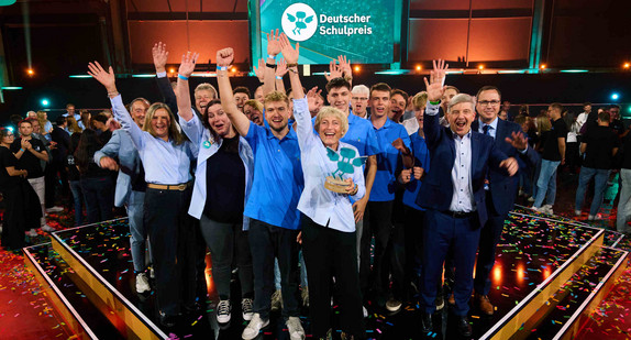 Jubelnde Vertreterinnen und Vertreter der Ferdinand-von-Steinbeis-Schule Tuttlingen mit Staatssekretär Andreas Deuschle auf der Bühne bei der Verleihung des Deutschen Schulpreises