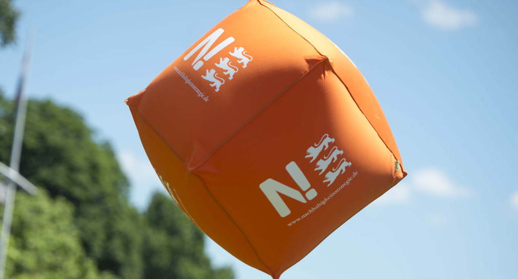 Würfel mit Logo der Nachhaltigkeitsstrategie fliegt durch die Luft (Bild: © Umweltministerium Baden-Württemberg)