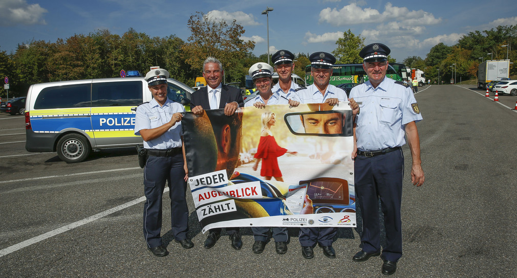 Innenminister Thomas Strobl und Polizistinnen und Polizisten mit einem Plakat zur Verkehrsssicherheitsaktion „sicher.mobil.leben“ (Foto: © Innenministerium Baden-Württemberg)