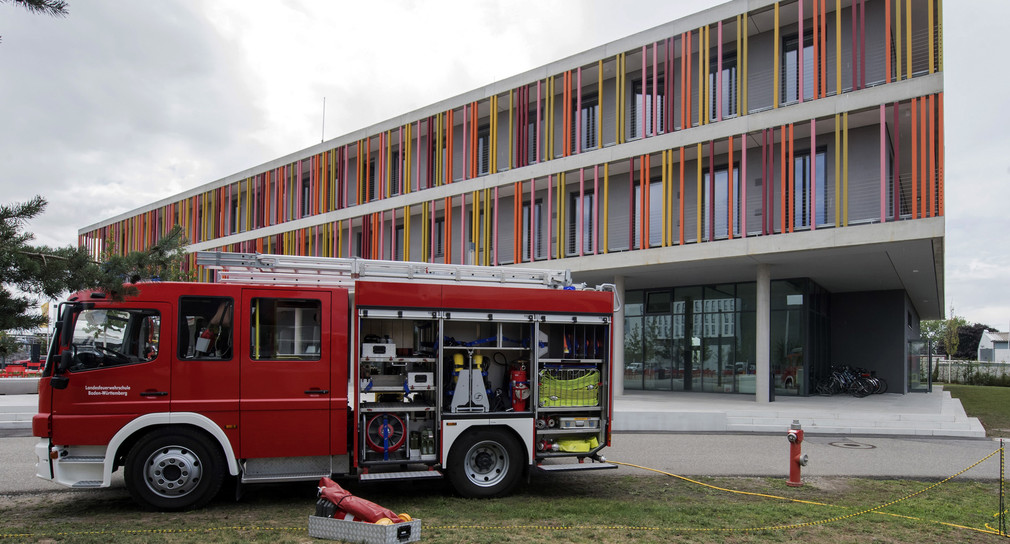 Ein Einsatzwagen der Feuerwehr steht in Bruchsal (Baden-Württemberg) vor einem der Neubauten der Landesfeuerwehrschule. (Bild: © dpa)