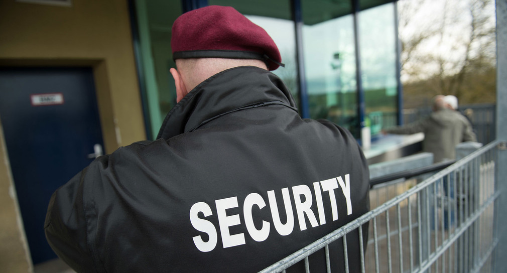 Ein Mitarbeiter einer Sicherheitsfirma trägt eine Jacke mit der Aufschrift „Security“.