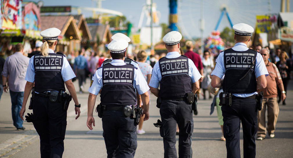 Polizisten laufen beim Cannstatter Volksfest über den Cannstatter Wasen. (Bild: © dpa)