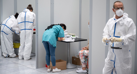 Mitarbeiter arbeiten im Corona-Testzentrum am Stuttgarter Flughafen. (Bild: © picture alliance/Sebastian Gollnow/dpa)