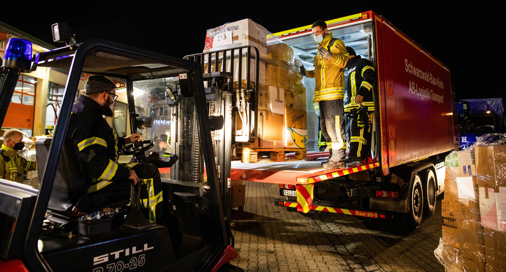 Feuerwehrleute verladen eine Palette mit Hilfsgütern für das kroatische Erdbebengebiet auf einen LKW. 