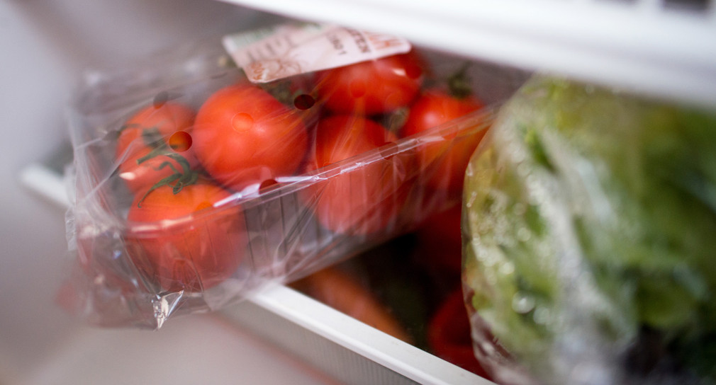 In Plastik verpackte Tomaten und Salatherzen liegen in einem Kühlschrank. (Foto: © dpa)