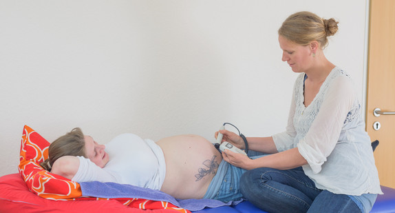 Hebamme führt Ultraschall an einer Schwangeren durch. (Bild: Thorsten Helmerichs / dpa)