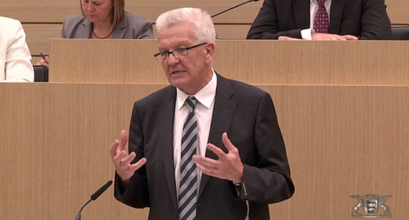 Ministerpräsident Winfried Kretschmann steht am Rednerpult im Landtag von Baden-Württemberg