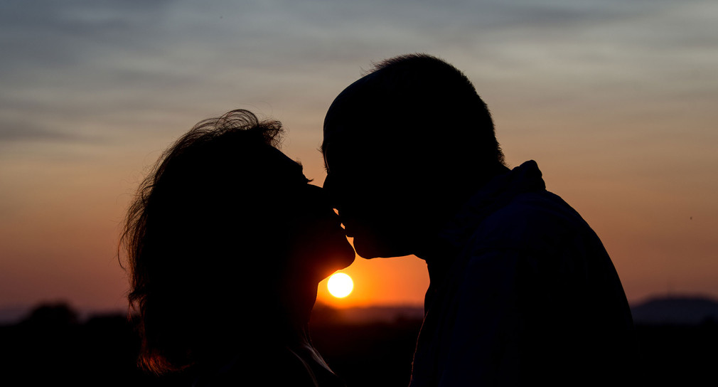 Ein Paar küsst in Freiburg im Sonnenuntergang (Bild: © dpa). 
