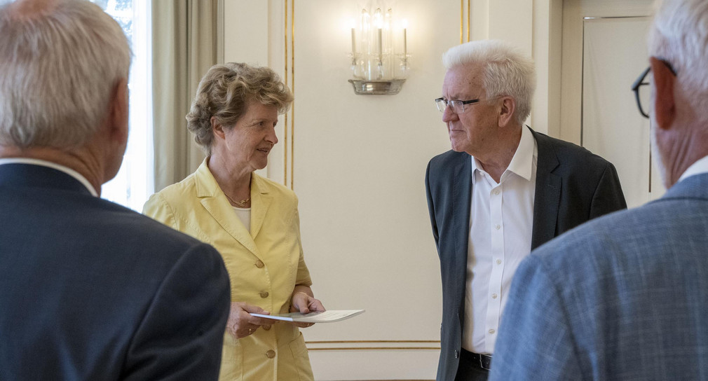 Dr. Gisela Meister-Scheufelen (zweite von links), Vorsitzende des Normenkontrollrats Baden-Württemberg, übergibt Ministerpräsident Winfried Kretschmann (zweiter von rechts) denJahres- und Bilanzbericht 2021.
