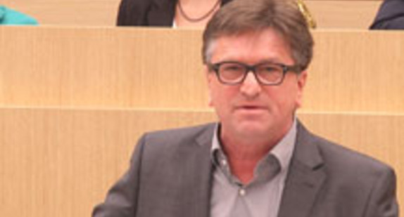 Manne Lucha, Minister für Soziales und Integration, steht im Landtag von Baden-Württemberg am Rednerpult.